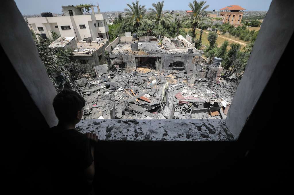 -FOTODELDÍA- EA5751. BEIT HANUN, 12/05/2023.-Un niño observa desde una ventana los restos de la casa de la familia Abu Khatir tras resultar alcanzada en un ataque con cohetes del Ejército de Israel, este viernes en Beit Hanun, en la Franja de Gaza. Israel y Gaza vivieron una noche de calma, tras una jornada el jueves de intenso intercambio de fuego, entre rumores de que una tregua podría anunciarse en las próximas horas para poner fin a una escalada que se ha cobrado la vida de 30 personas en la Franja y una de lado israelí. EFE/ Mohammed Saber