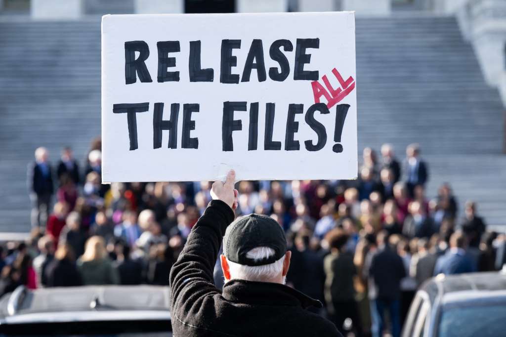 TOPSHOT - A protester holds a sign related to the release of the Jeffrey Epstein case files outside the US Capitol in Washington, DC, November 12, 2025.