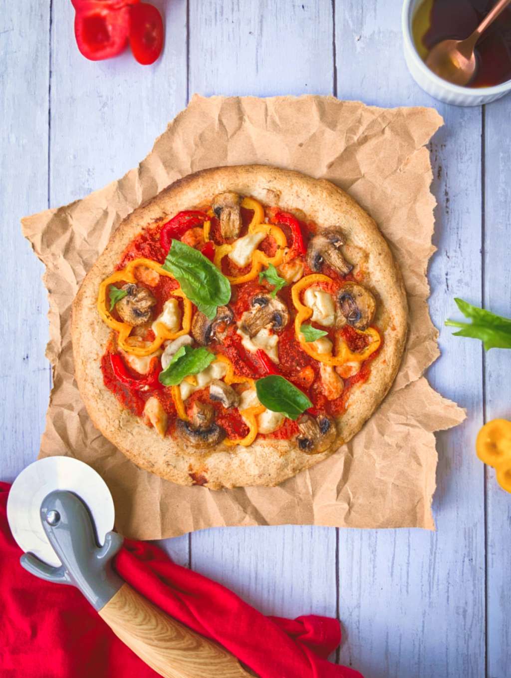 Los champiñones, los pimentones de colores y la albahaca fresca van muy bien con esta pizza.