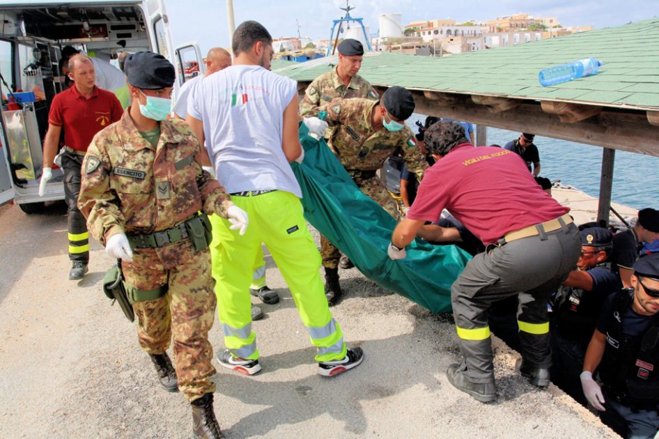 Fotografía facilitada por la Armada de Italia que muestra a varias personas que trasladan el cuerpo de uno de los 134 inmigrantes muertos, tras el naufragio de una barcaza que intentaba llegar a la isla de Lampedusa./ EFE