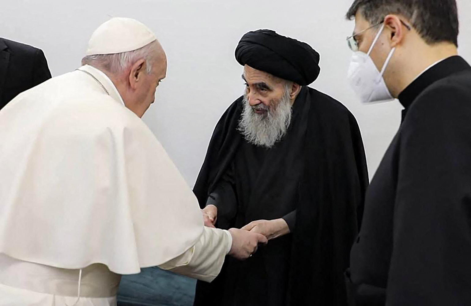 (FILES) This handout picture released by Ayatollah Sistani's media office shows Iraq's most revered Shiite cleric, Grand Ayatollah Ali al-Sistani (C) meeting with Pope Francis (L) and his delegation, at his home in the holy city of Najaf, on March 6, 2021.