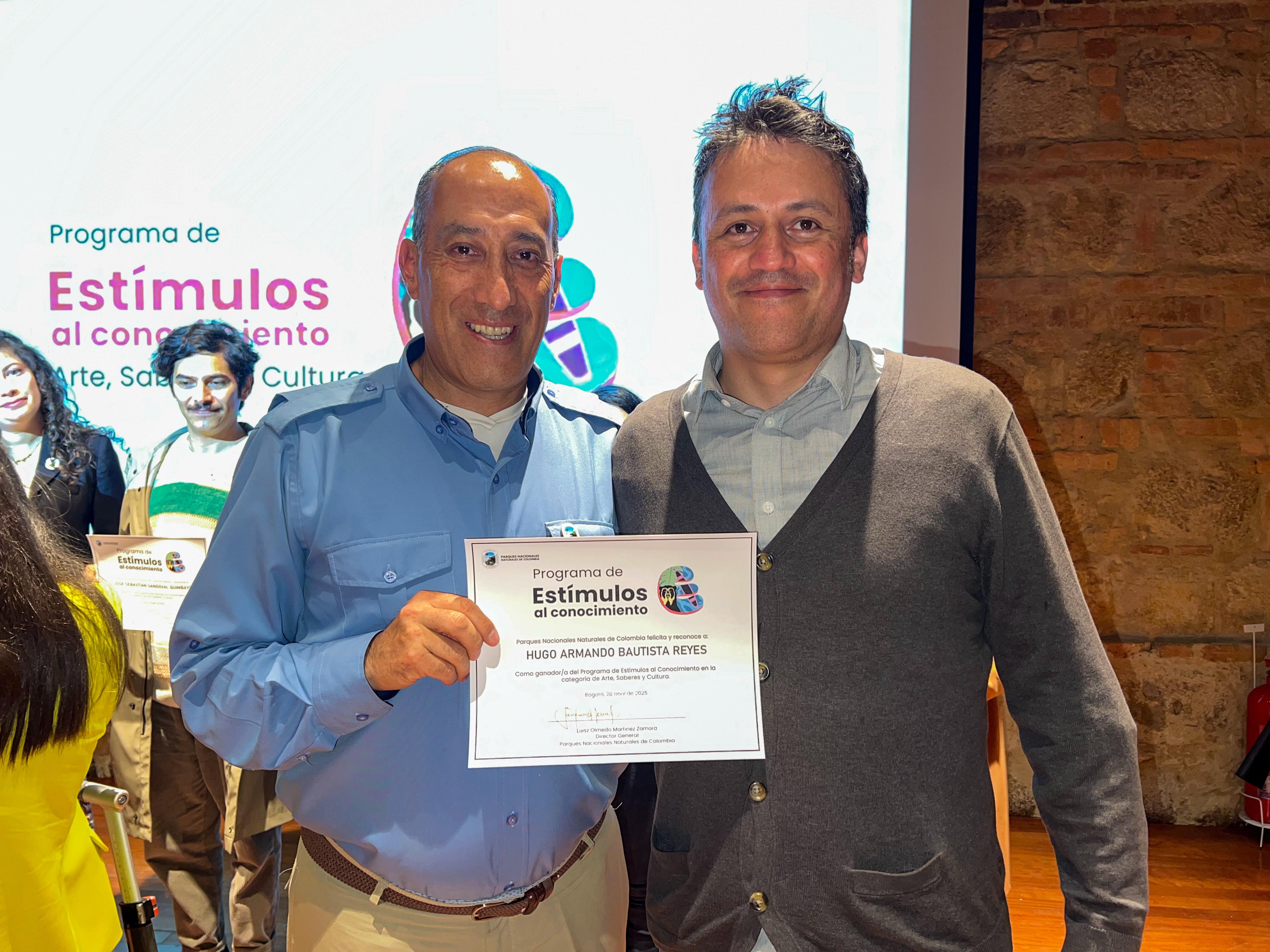 Luisz Olmedo Martínez, director de PNN, con un ganador del programa de estímulos.
