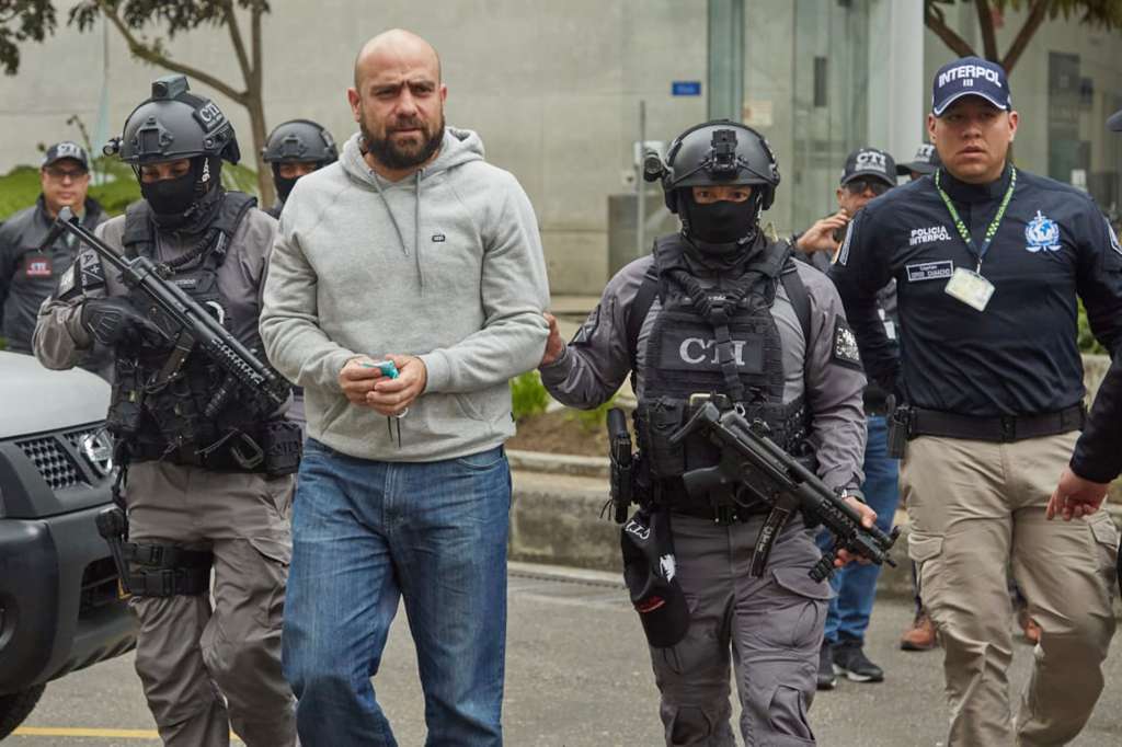 AME6154. BOGOTÁ (COLOMBIA), 10/09/2022.- Fotografía cedida por la Fiscalía de Colombia que muestra a integrantes del Cuerpo Técnico de Investigación (CTI) de la Policía y la Interpol mientras trasladan coronel de la Policía colombiana Benjamín Núñez (c), hoy, en el Búnker de la Fiscalía en Bogotá (Colombia). El coronel de la Policía colombiana Benjamín Núñez, implicado en el asesinato de tres jóvenes el pasado 25, de julio en el departamento caribeño de Sucre, llegó a Bogotá en un vuelo comercial tras haberse entregado en México el viernes, informaron este sábado las autoridades. EFE/ Fiscalía De Colombia SÓLO USO EDITORIAL/SÓLO DISPONIBLE PARA ILUSTRAR LA NOTICIA QUE ACOMPAÑA (CRÉDITO OBLIGATORIO)