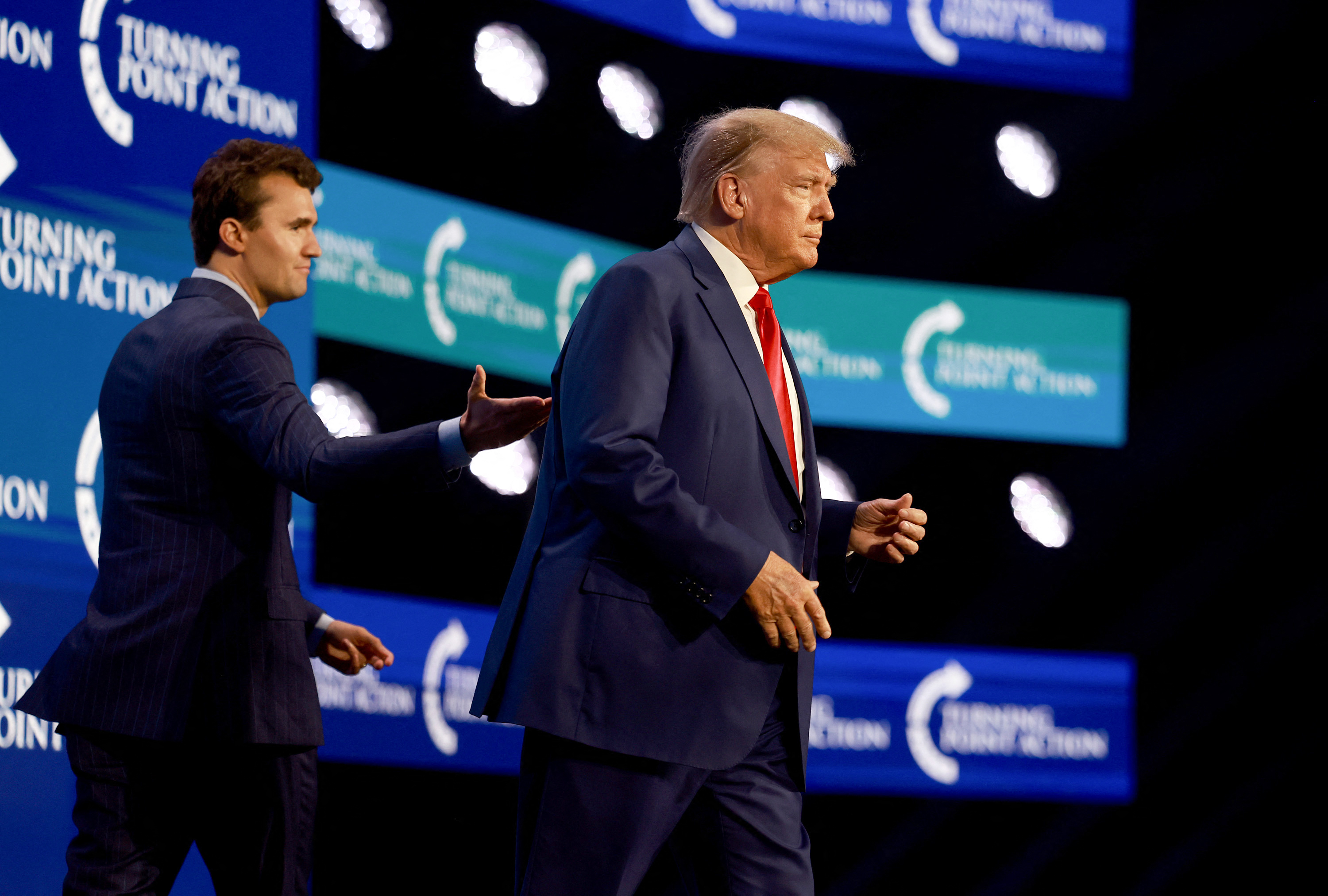(FILES) Former US President Donald Trump walks on stage after being introduced by Charlie Kirk (L) at the Turning Point Action conference as he continues his 2024 presidential campaign on July 15, 2023 in West Palm Beach, Florida.