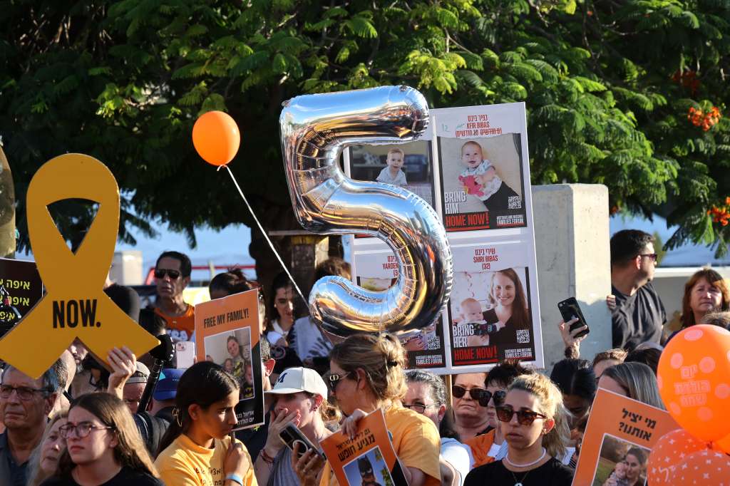 Participants lift placards and pictures during a gathering in Tel Aviv on August 5, 2024 to mark the fifth birthday of Ariel Bibas, held hostage in Gaza, and to call for the liberation of him and his family.
