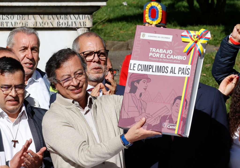 AME8517. BOGOTÁ (COLOMBIA), 25/06/2025.- El presidente de Colombia, Gustavo Petro, sostiene un libro que simboliza la reforma laboral este miércoles, en Bogotá (Colombia). Petro firmó la ley de la reforma laboral, cinco días después de que el Congreso aprobara esta iniciativa que se convirtió en una de las mayores victorias legislativas de su Gobierno. EFE/ Mauricio Dueñas Castañeda