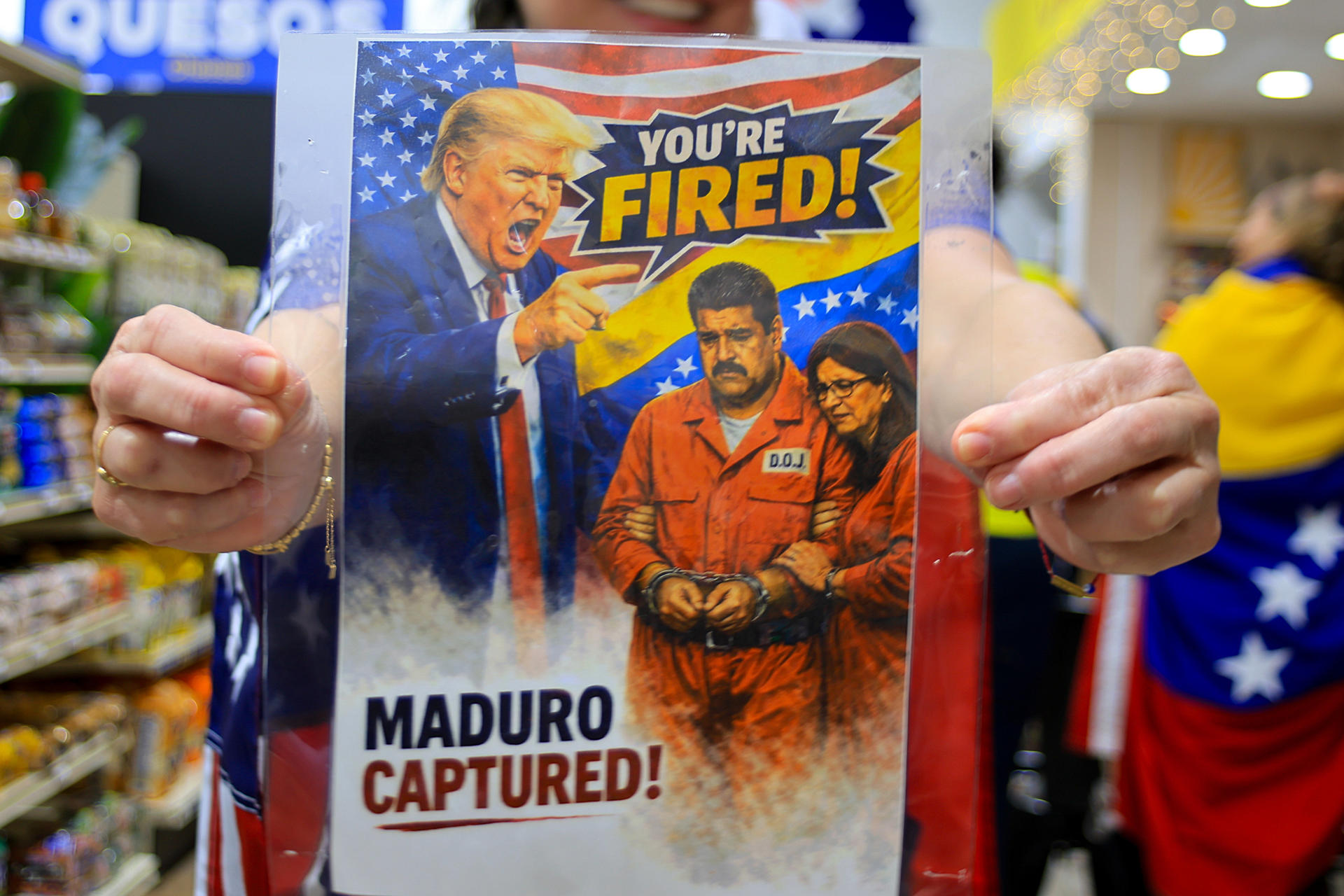 FOTODELDÍA AME1874. HOUSTON (ESTADOS UNIDOS), 03/01/2026.- Una persona sostiene un cartel durante una concentración este sábado, en Houston (Estados Unidos). Venezolanos residentes en Houston salieron a las calles para festejar la captura del presidente de Venezuela, Nicolás Maduro, por parte de las fuerzas militares estadounidenses. EFE/ Carlos Ramírez