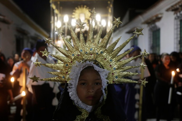 SAN400. SANTA CRUZ DE MOMPOX (COLOMBIA), 30/03/2024.- Una niña conmemora el Viernes Santo con la procesión del Santo Sepulcro, acompañados por una imagen de la virgen, los caballeros de Jesucristo, las mujeres alumbradoras y los nazarenos de Santa Cruz, este viernes, en Mompox (Colombia). La procesión que transita acompañada por una banda de música de luto recorre las calles del centro histórico de este pueblo que fue declarado por Unesco en 1995 como patrimonio de la humanidad. EFE/Ricardo Maldonado Rozo