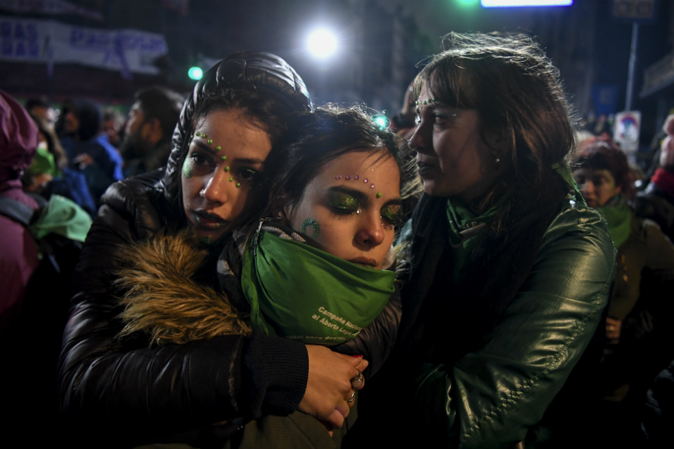 Activistas a favor de la legalización del aborto se consuelan a las afueras del Congreso Nacional en Buenos Aires tras la decisión del Senado de rechazar el proyecto de ley. / AFP