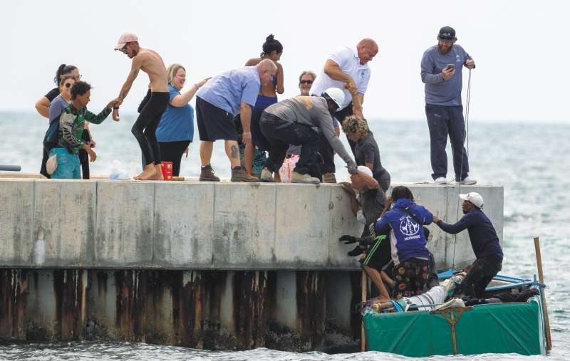 Los residentes ayudan a los inmigrantes cubanos a llegar a la costa cerca de Key West, Florida, el viernes 12 de agosto de 2022. El número de cubanos que abandonarán la isla alcanzará un máximo histórico este año. La Guardia Costera de Estados Unidos ha interceptado a muchos en el mar, pero muchos más están cruzando la frontera entre Estados Unidos y México. (Foto AP/Mary Martín)
