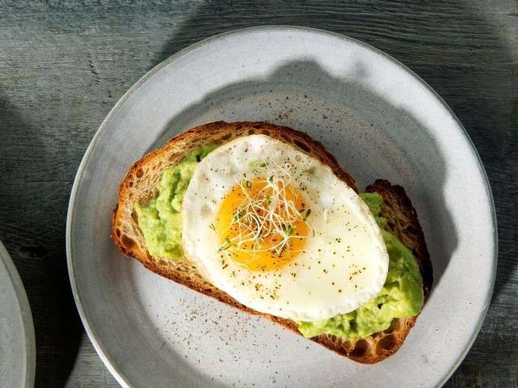 Prueba un huevo escalfado sobre medio aguacate para un desayuno rico en proteínas y grasas saludables.