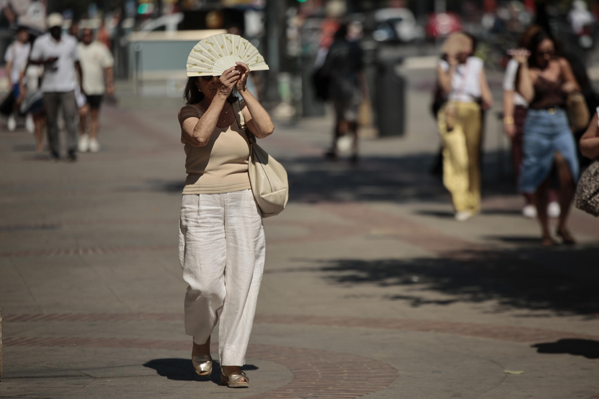 FOTODELDÍA GRAFCVA4906. VALENCIA, 06/07/2026.- Una mujer se protege del calor con un abanico durante este lunes en el que la Agencia Estatal de Meteorología (Aemet) ha advertido de que esta semana se prevé una nueva ola de calor en la Comunitat Valenciana, con especial intensidad a partir de este lunes y, al menos, hasta el jueves, con el pico más intenso entre el martes y el jueves. EFE/Biel Aliño