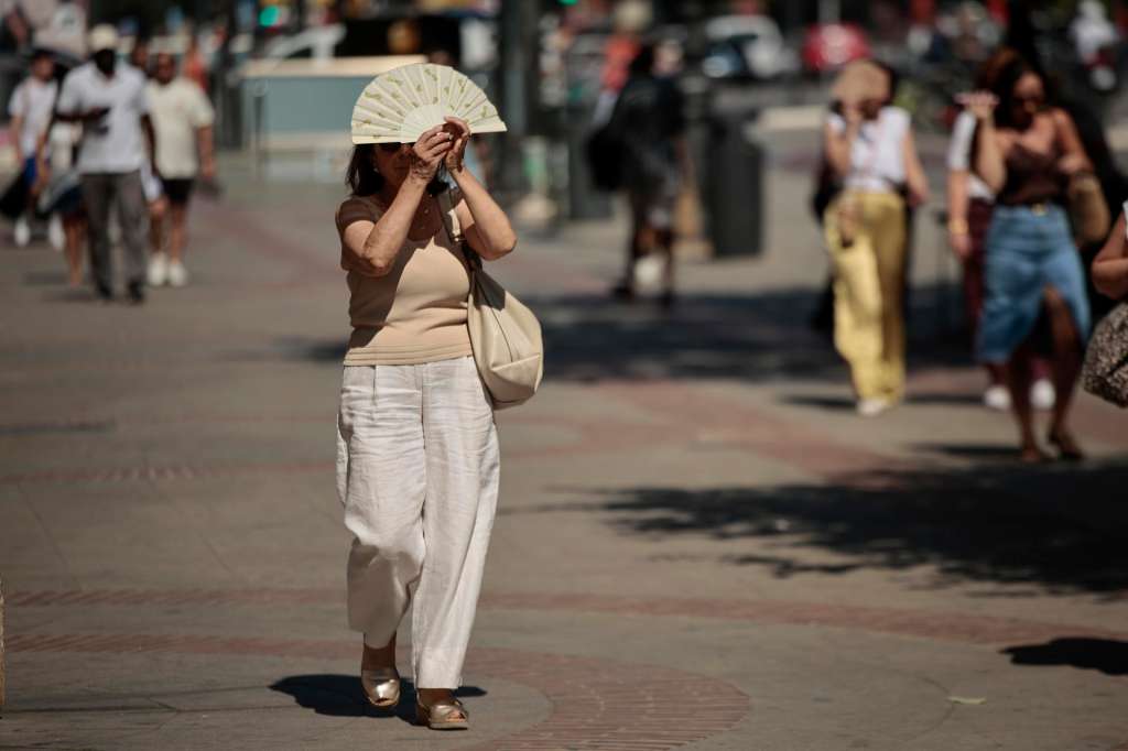FOTODELDÍA GRAFCVA4906. VALENCIA, 06/07/2026.- Una mujer se protege del calor con un abanico durante este lunes en el que la Agencia Estatal de Meteorología (Aemet) ha advertido de que esta semana se prevé una nueva ola de calor en la Comunitat Valenciana, con especial intensidad a partir de este lunes y, al menos, hasta el jueves, con el pico más intenso entre el martes y el jueves. EFE/Biel Aliño
