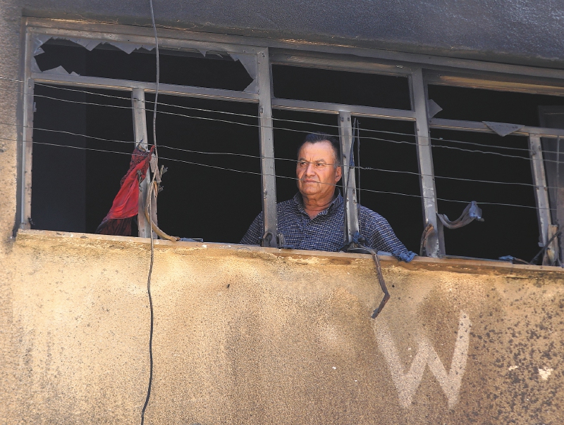 Un hombre mira desde la ventana rota de un edificio en el campo de refugiados de Yenín, en Cisjordania, tras una operación militar israelí a gran escala en julio pasado.