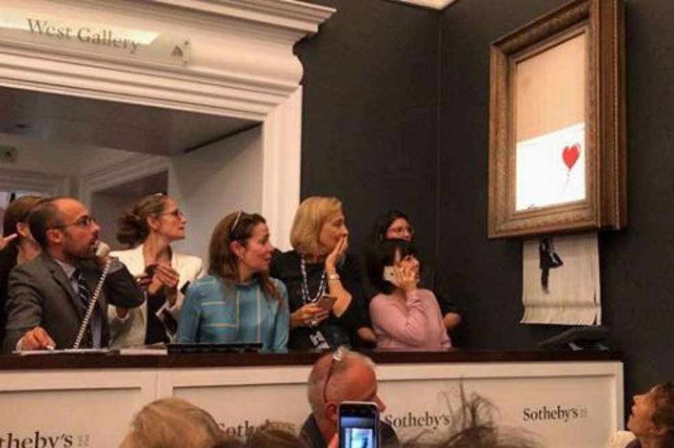 Ante la atónita mirada de los participantes de la subasta, la obra "Niña con globo" de Banksy quedó triturada en varios pedazos. Captura pantalla / Captura de pantalla