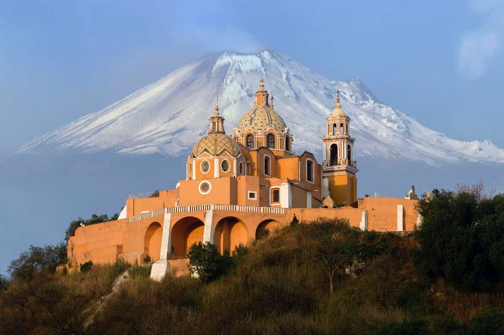 CholulaCortesíaUna actividad sugerida para hacer en este destino es recorrer los ocho kilómetros de túneles dentro de la gran pirámide de Cholula, considerada la más grande del mundo, con un tamaño de 430 a 460 metros por lado y con una altura de más de 60 metros. Para darnos una idea de su dimensión, en la base de esta pirámide entraría dos veces la Pirámide del Sol de Teotihuacán.