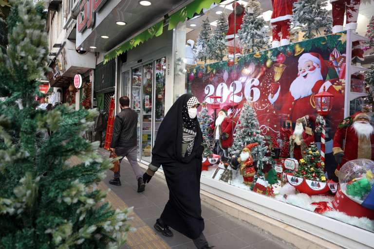 TEHRAN (IRAN(Islamic Republic Of)), 23/12/2025.- A veiled Iranian woman walk pasts a shop selling Christmas items in Tehran, Iran, 23 December 2025. Approximately 150,000 Christians live in Iran, with Armenians constituting the majority. They celebrate Christmas in churches and privately at home. Some Muslim families have also adopted a few Christmas traditions, buying presents and even Christmas trees for their children to enjoy. (Teherán) EFE/EPA/ABEDIN TAHERKENAREH