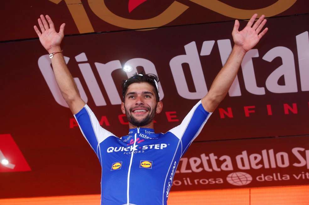 Fernando Gaviria subió ayer tres veces al podio. Primero como ganador de la etapa, luego a recibir la magia rosa y luego a vestirse de blanco por ser el mejor sub-23. / AFP