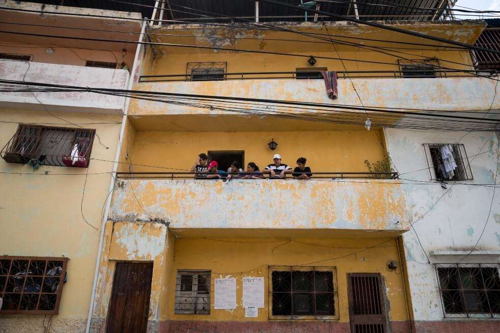 Evelyn Martínez (c) junto a su familia asomándose al balcón en su casa en el sector popular Antímano, en Caracas (Venezuela). / EFE