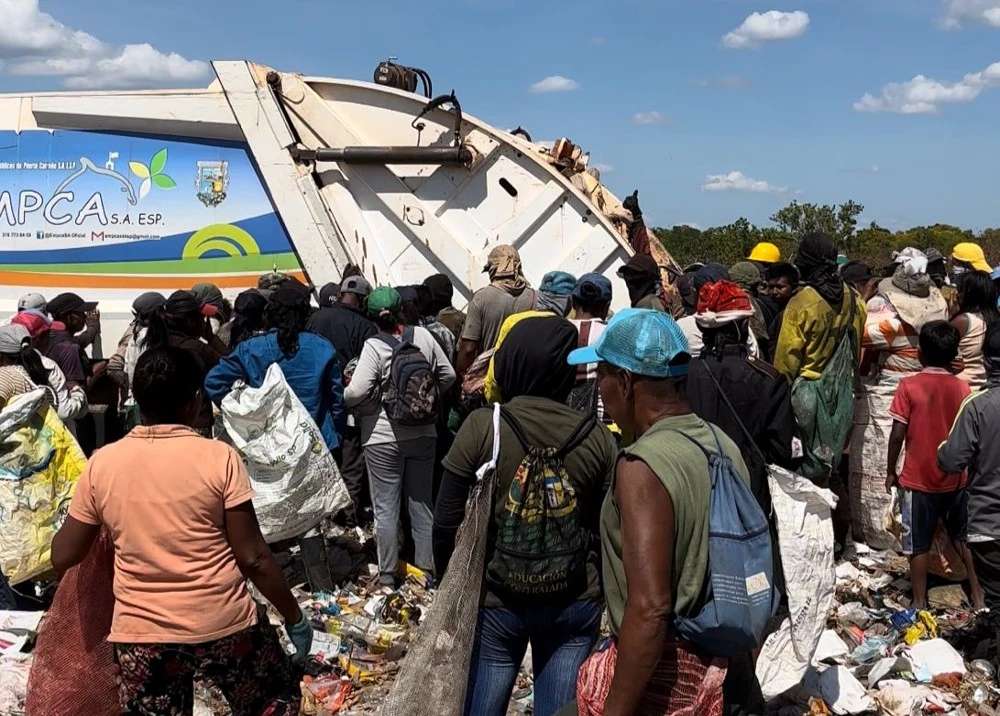 Se observa a personas alrededor de las basuras.