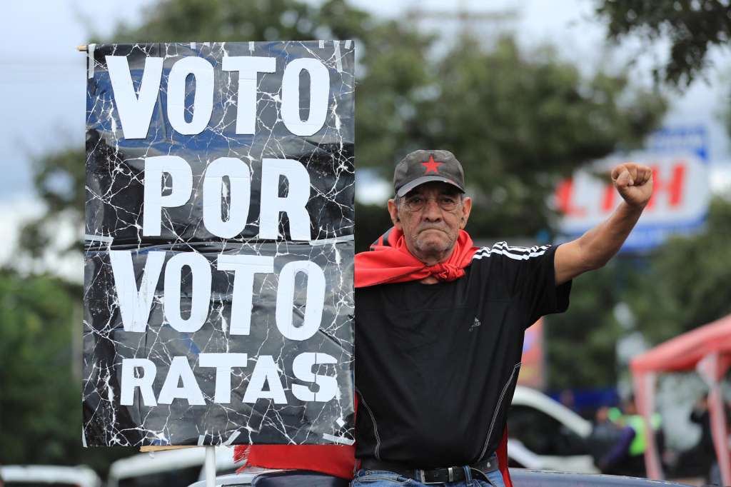 AME8834. TEGUCIGALPA (HONDURAS), 16/12/2025.- Un simpatizante del Partido Libertad y Refundación (Libre) protesta frente al Instituto Nacional de Formación Profesional (Infop), lugar donde se encuentra el Centro Logístico Electoral, este martes en Tegucigalpa (Honduras). Los hondureños siguen sin conocer los resultados de las elecciones generales del pasado 30 de noviembre, por problemas que no han sido superados por el Consejo Nacional Electoral (CNE), al que le restan dos semanas para que anuncie al nuevo presidente electo y otras autoridades. EFE/ Gustavo Amador