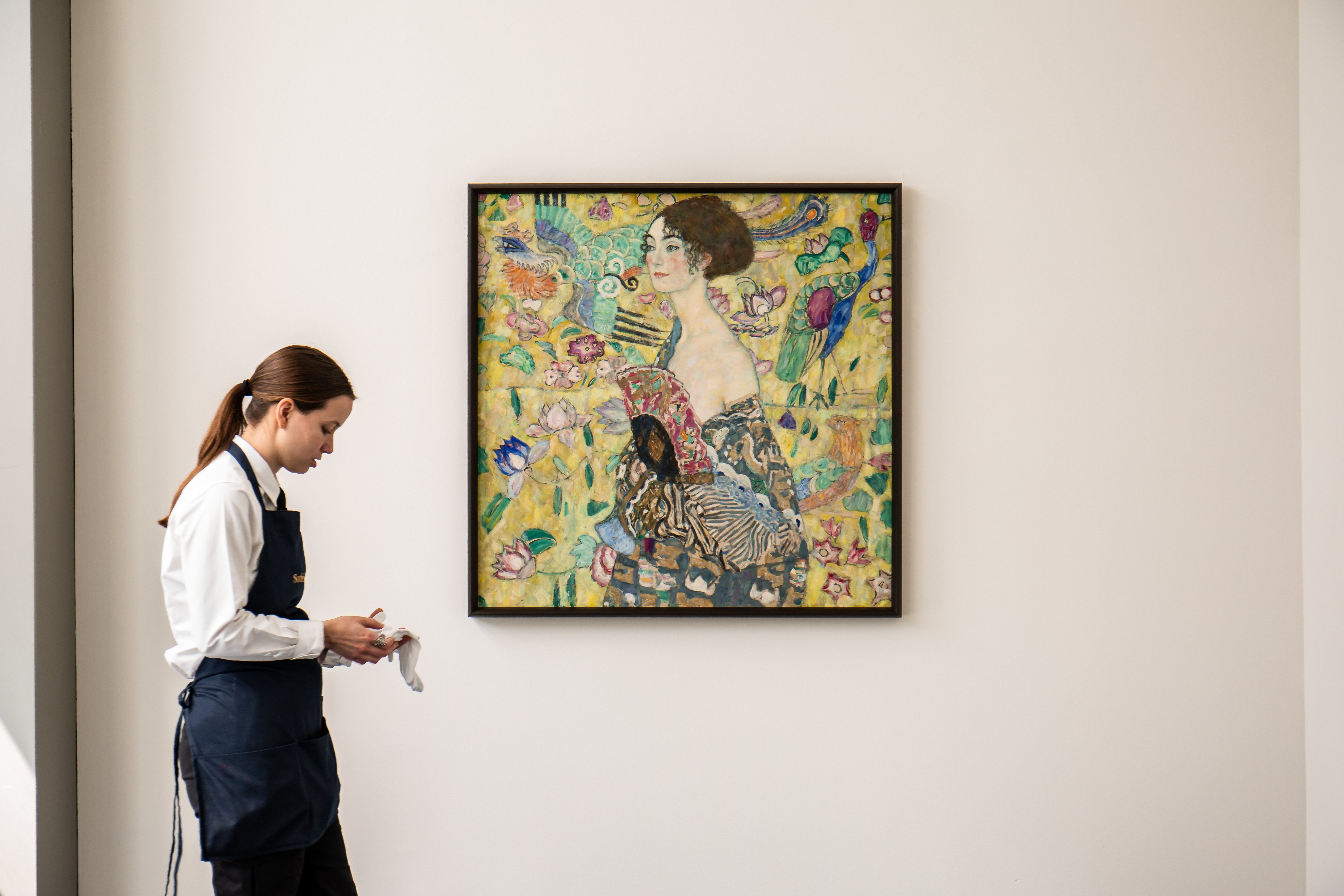 MADRID, 14/06/2023.- Una mujer junto al retrato del pintor austríaco Gustav Klimt, "Dama con Abanico", que se pondrá a subasta el 27 de junio por la casa de pujas Sotheby's en Londres y que ha anunciado este martes que espera alcanzar por la obra la cifra de 65 millones de libras, es decir, 80 millones de euros. EFE/Sotheby's/*****SOLO USO EDITORIAL/SOLO DISPONIBLE PARA ILUSTRAR LA NOTICIA QUE ACOMPAÑA (CRÉDITO OBLIGATORIO) *****