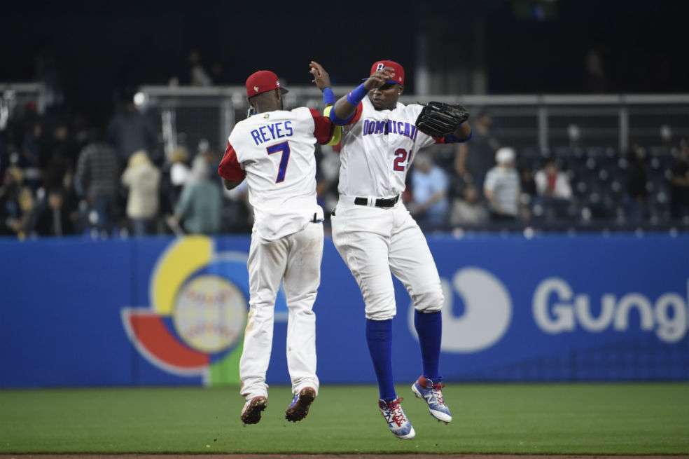 Los dominicanos José Reyes y Gregory Polanco celebran la victoria contra Venezuela. / AFP