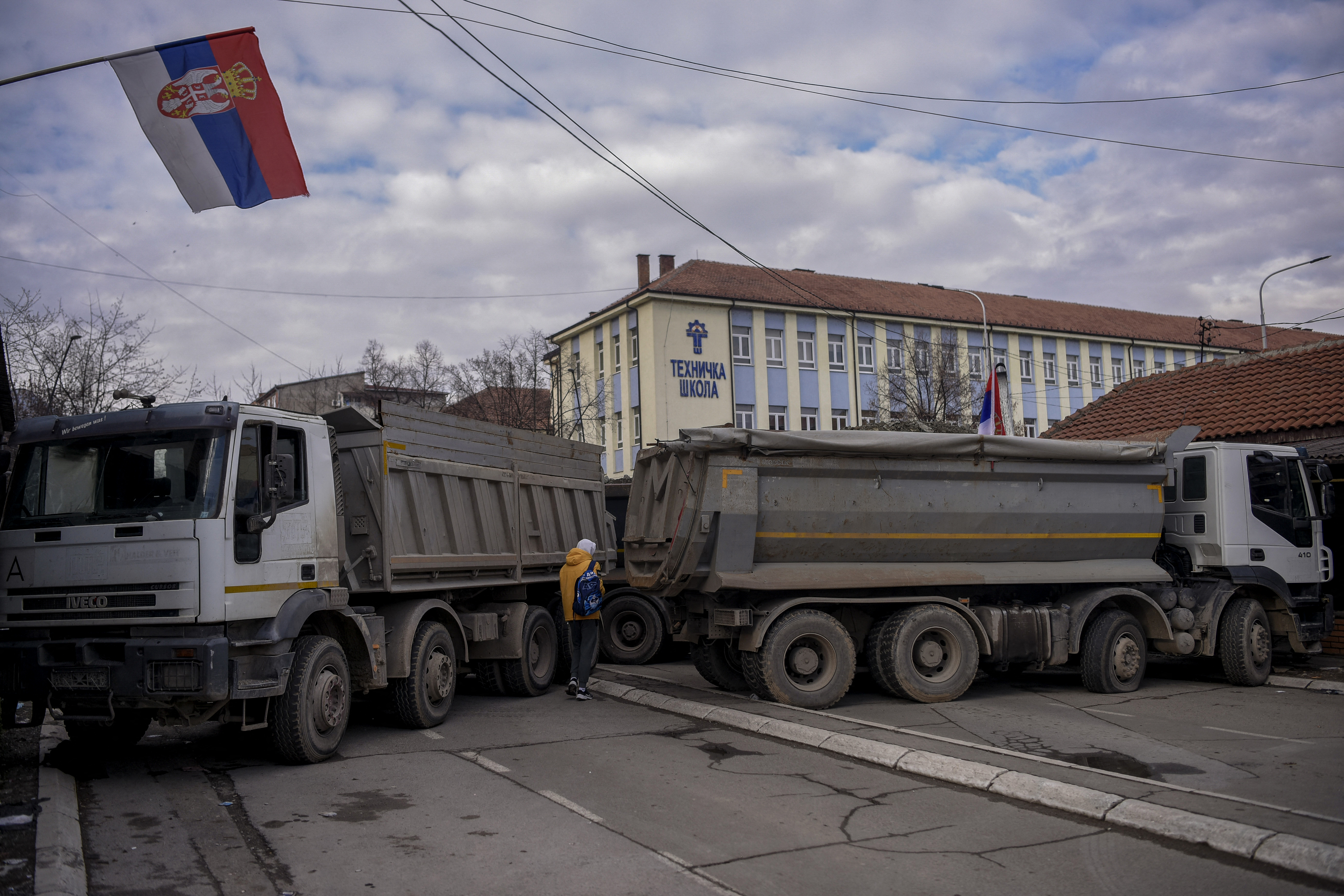 Un peatón pasa frente a una nueva barricada instalada en la ciudad dividida de Mitrovica el 28 de diciembre de 2022.
