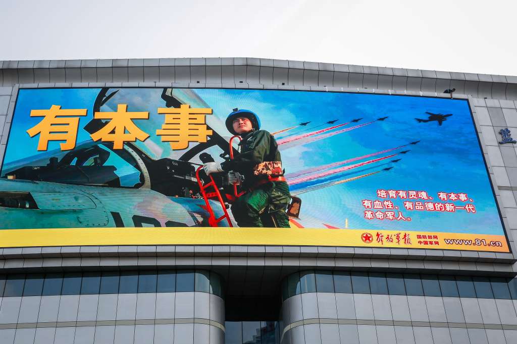 Beijing (China), 01/08/2022.- A man (top-R) puts a tape along an advertisement to mark the 95th founding anniversary of the People's Liberation Army (PLA) displayed in Beijing, China, 01 August, 2022. China has raised a warning stating its military will not sit idle if US House of Representatives Speaker Nancy Pelosi visits Taiwan. Pelosi is leading a Congressional delegation to the Indo-Pacific region with a visit to Singapore, Malaysia, South Korea and Japan. (Japón, Corea del Sur, Malasia, Singapur, Estados Unidos, Singapur) EFE/EPA/MARK R. CRISTINO