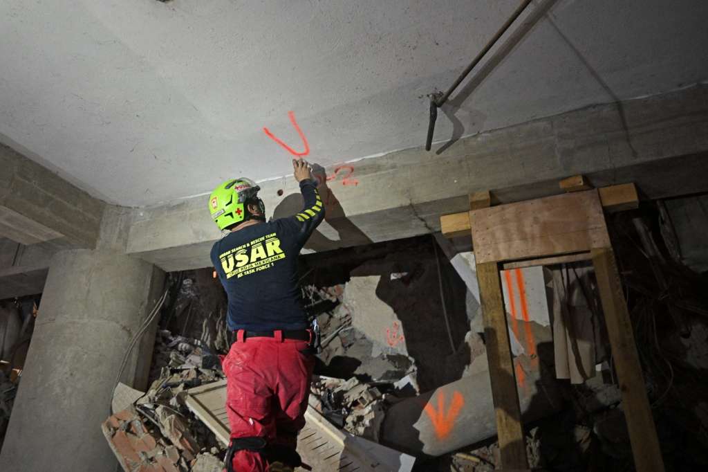 Un rescatista estadounidense marca con la letra "V" (de víctimas) una pared en el garaje del edificio de donde fue rescatado Hernán Gil, en Catia La Mar, La Guaira (Venezuela).