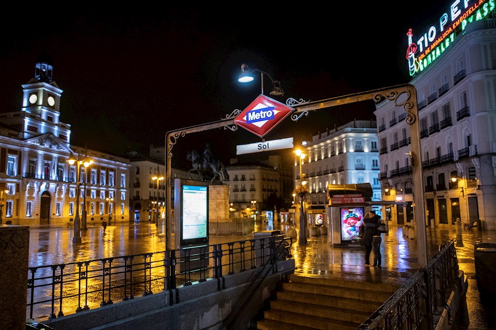 Una pareja se despide junto a la entrada del Metro de la Puerta del Sol, anoche, en la primera jornada de toque de queda en la capital. Esta medianoche ha comenzado el toque de queda en toda la Comunidad de Madrid que tendrá lugar de 00.00 a 6.00 horas mientras dure el estado de alarma en España, una medida que se suma a las restricciones de movilidad en 32 zonas básicas de salud de la región donde no estará permitido entrar ni salir salvo por motivos justificados, como ir a trabajar.