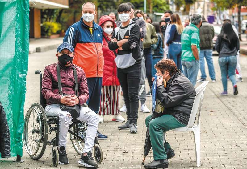 Personas haciendo fila en Bogotá para una prueba de Covid. / AFP / Juan BARRETO