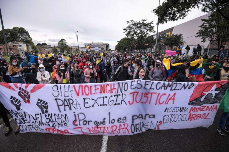 Varias personas marchando sobre una avenida