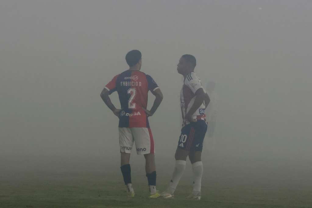 AME365. CARTAGENA (COLOMBIA), 07/05/2026.- Luis Fernando Muriel (d) de Junior y Fabricio Domínguez de Cerro esperan que disperse el humo de unas bengalas este jueves, durante un partido de la fase de grupos de la Copa Libertadores entre Junior y Cerro Porteño en el estadio Romelio Martínez en Cartagena (Colombia). EFE/ Ricardo Maldonado Rozo