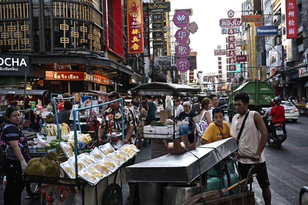 This photo taken on April 29, 2026 shows street food vendors moving their carts before evening rush hour in Chinatown in Bangkok.