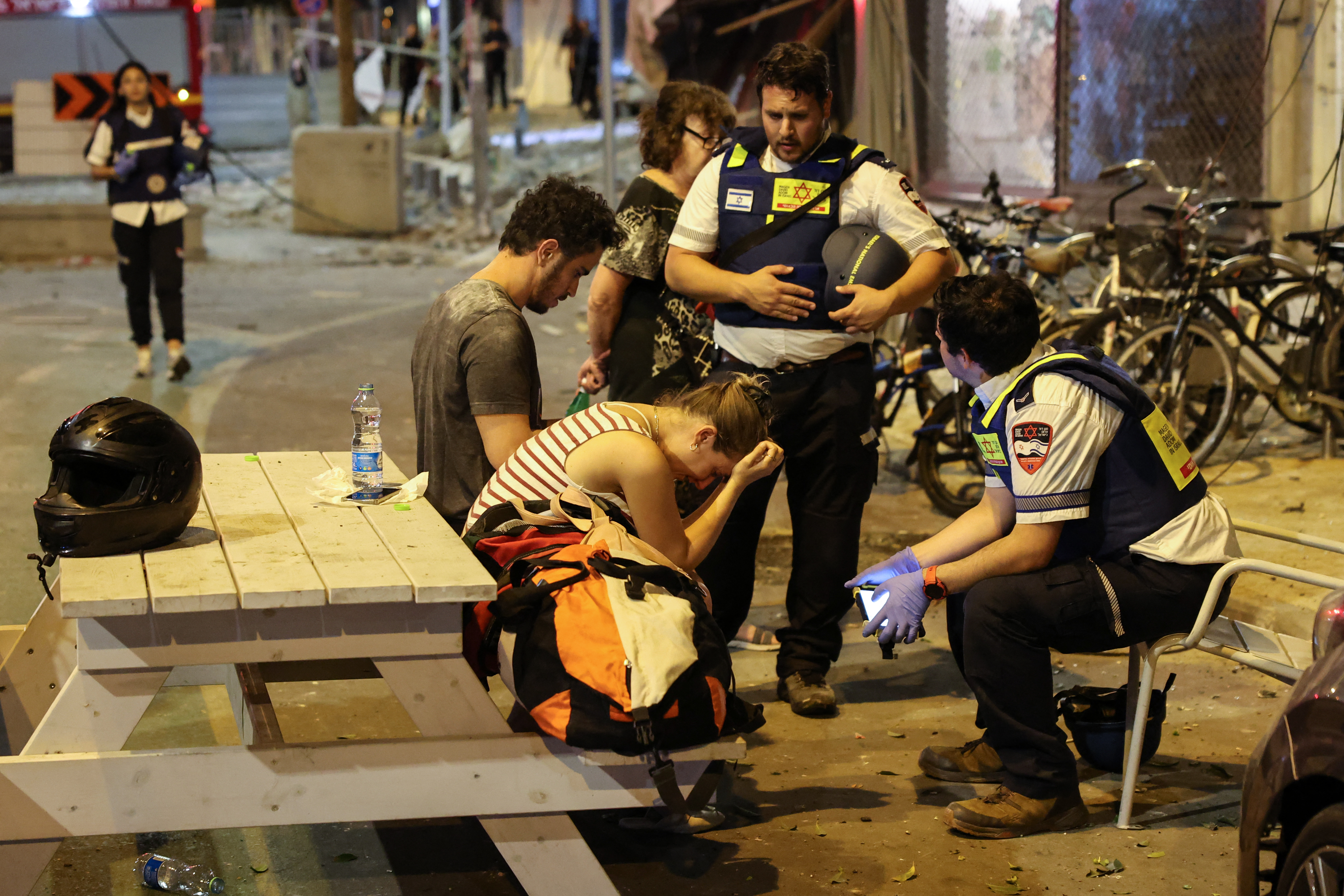 Una joven reacciona mientras habla con los rescatistas israelíes en Tel Aviv, después de que un cohete disparado por militantes palestinos desde la Franja de Gaza el 7 de octubre de 2023. El grupo militante palestino Hamás lanzó un ataque sorpresa a gran escala contra Israel en octubre. El 7 de septiembre, se dispararon miles de cohetes desde Gaza y se enviaron combatientes a matar o secuestrar personas mientras Israel respondía con devastadores ataques aéreos.