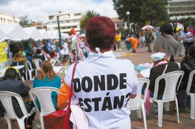 Una mujer de espaldas tiene una camiseta que dice "¿Dónde están?", haciendo referencias a los desaparecidos en Colombia.