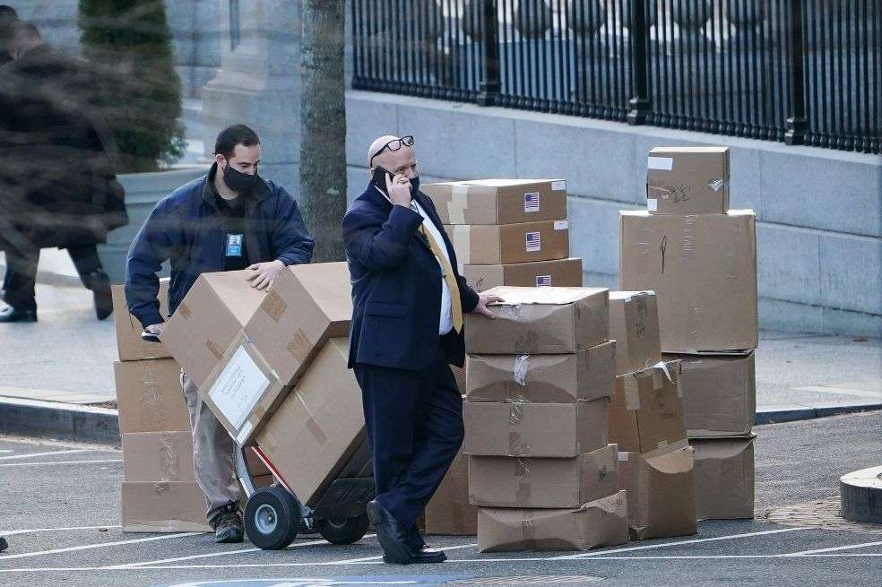 Un trabajador apila cajas en la West Executive Avenue antes de cargarlas en un camión en la Casa Blanca en Washington, D.C.