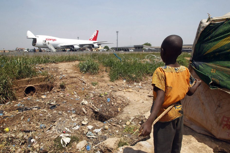 Un niño de un campo de refugiados cercano al aeropuerto de Mpoko observa un avión de carga del Programa Mundial de Alimentos (WFP)./ EFE