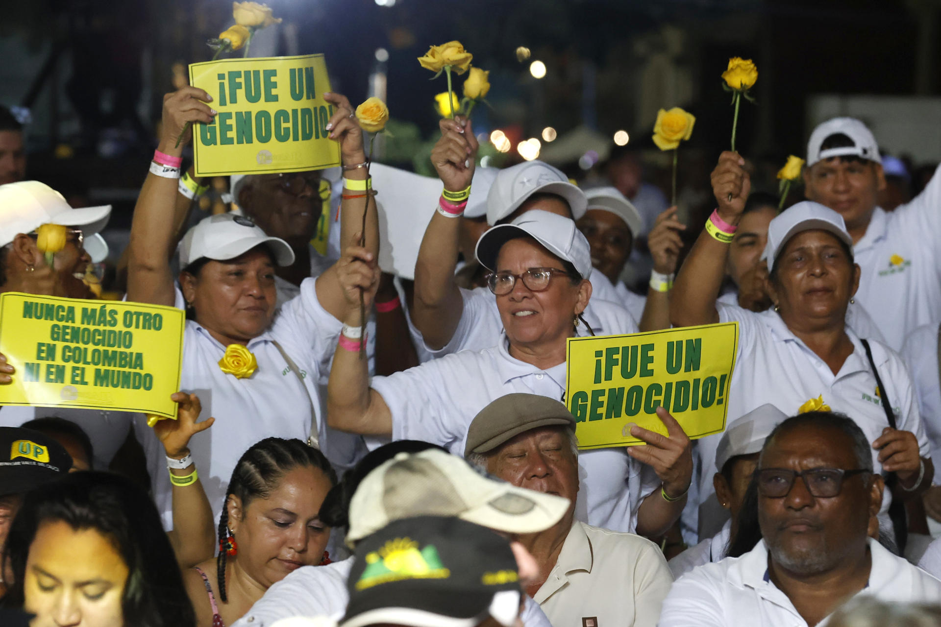 AME7591. SANTA MARTA (COLOMBIA), 09/11/2025.- Personas sostienen carteles durante un acto de reconocimiento del estado colombiano este domingo, en Santa Marta (Colombia). El Estado colombiano reconoció su responsabilidad y pidió perdón por el exterminio de miles de militantes del partido izquierdista Unión Patriótica (UP) entre 1984 y 2002, en un acto encabezado por el presidente de Colombia, Gustavo Petro. EFE/ Mauricio Dueñas Castañeda