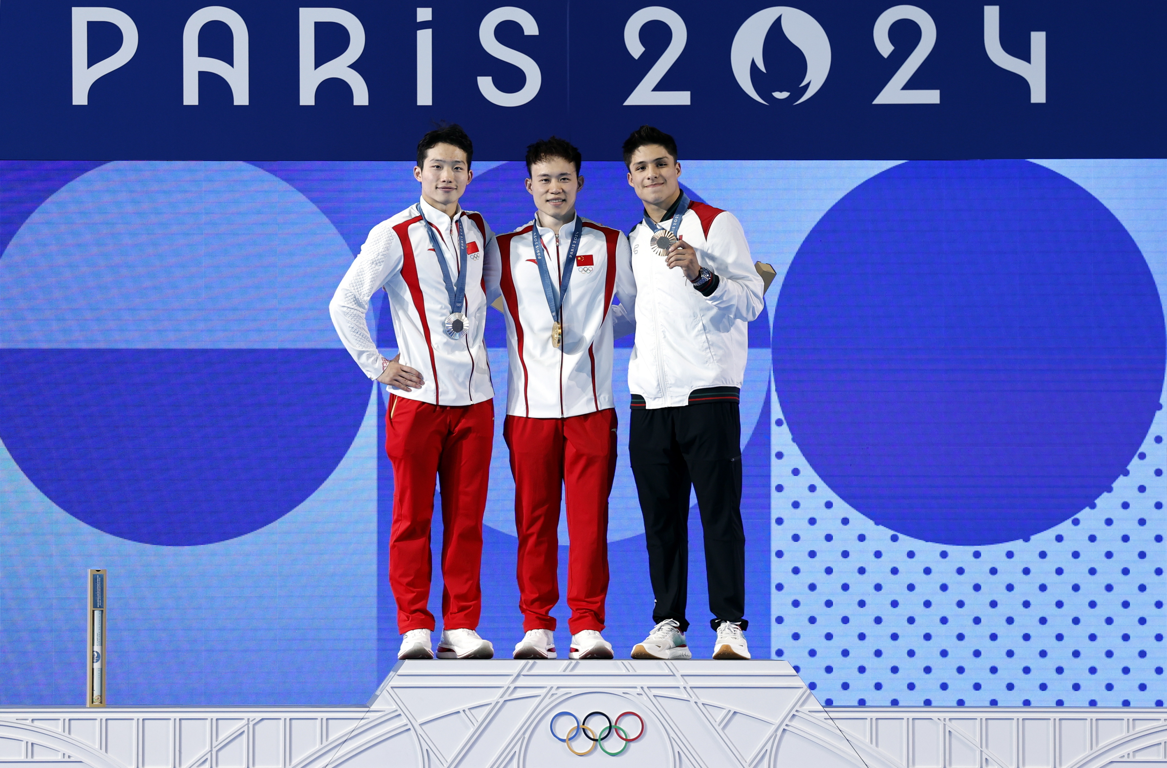 Saint-denis (France), 08/08/2024.- (L-R) Silver medalist Wang Zongyuan of China, gold medalist Xie Siyi of China, and bronze medalist Osmar Olvera Ibarra of Mexico pose on the podium during hte medal ceremony for the Men 3m Springboard Final of the Diving competitions in the Paris 2024 Olympic Games, at the Paris Aquatics Centre in Saint Denis, France, 08 August 2024. (Francia) EFE/EPA/TOLGA AKMEN