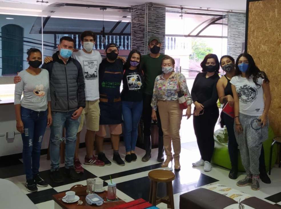 un grupo de personas está posando de pie, de frente hacia la cámara.