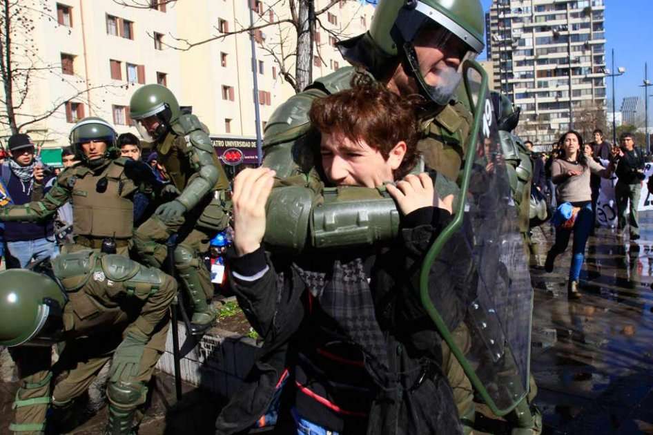 Un joven es detenido por la Policía en Santiago (Chile), en una concentración de estudiantes de secundaria que marcharon a favor de la educación, pero que fue disuelta por la policía, lo que derivó en violentos disturbios. Foto: EFE