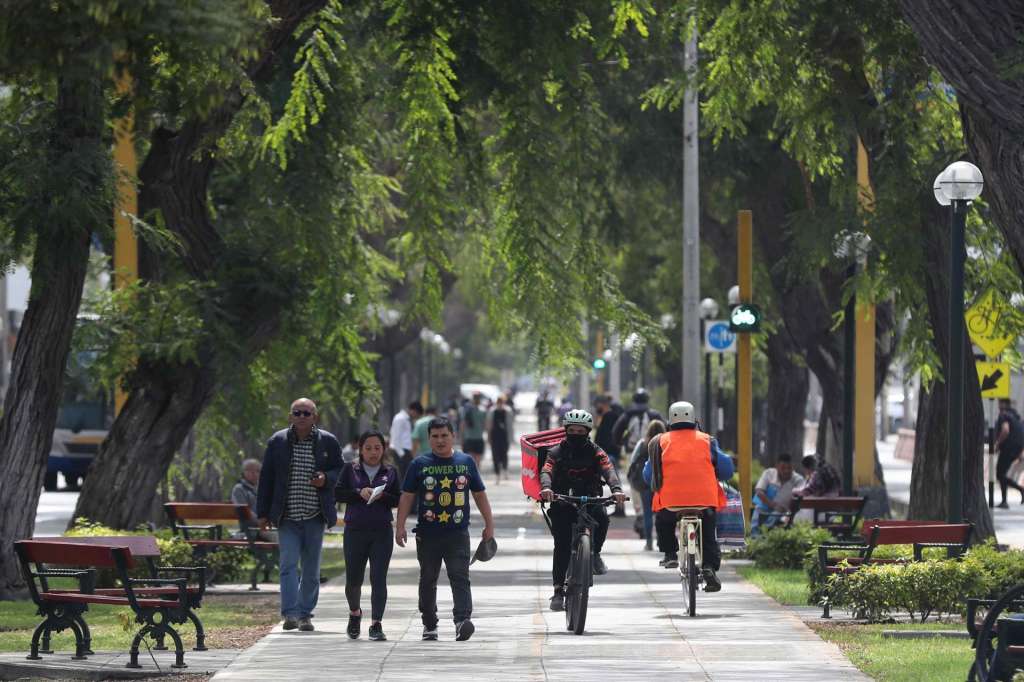 AME7588. LIMA (PERÚ), 14/05/2025.- Personas caminan por un sendero este miércoles, en Lima (Perú). El paro convocado en Perú por transportistas urbanos y otros gremios ante el aumento de la criminalidad no tuvo un seguimiento significativo en las primeras horas, por lo que el tráfico y la actividad comercial transcurrieron de forma casi normal en Lima, aunque en el departamento sureño de Puno hubo algunos bloqueos que afectaron la conexión con Bolivia. EFE/ Paolo Aguilar
