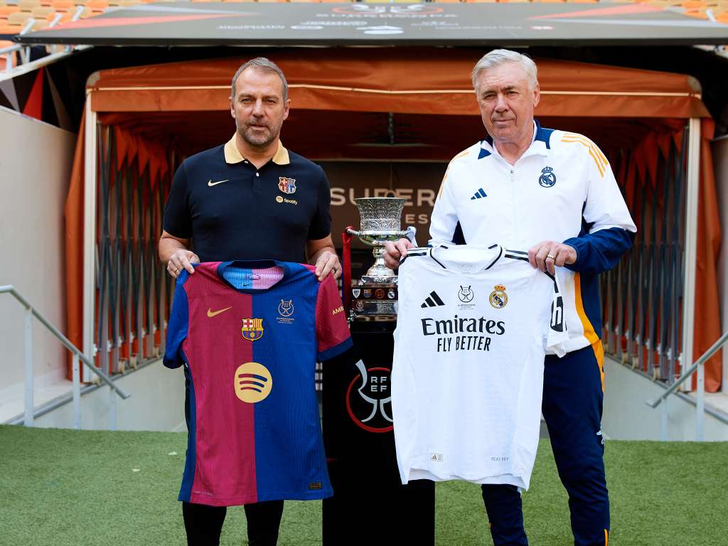YEDA (ARABIA SAUDÍ), 11/01/2025.- Los entrenadores del Real Madrid CF y el FC Barcelona, Carlo Ancelotti (d) y Hansi Flick (i), respectivamente, han posado este sábado junto al trofeo en el estadio Al Jawhara de Yeda, que mañana acogerá la final de la Supercopa de España. EFE/RFEF/David Aliaga -SOLO USO EDITORIAL/SOLO DISPONIBLE PARA ILUSTRAR LA NOTICIA QUE ACOMPAÑA (CRÉDITO OBLIGATORIO)-