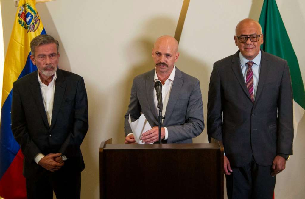 El director del Centro Noruego para la Resolución de Conflictos, Dag Nylander, habla durante una conferencia de prensa con el jefe de la delegación del gobierno venezolano, Jorge Rodríguez (der.) y el jefe de la delegación de la oposición venezolana, Gerardo Blyde Pérez (izq.), en el hotel donde se desarrollan las negociaciones entre el gobierno venezolano y la oposición en la Ciudad de México. / AFP