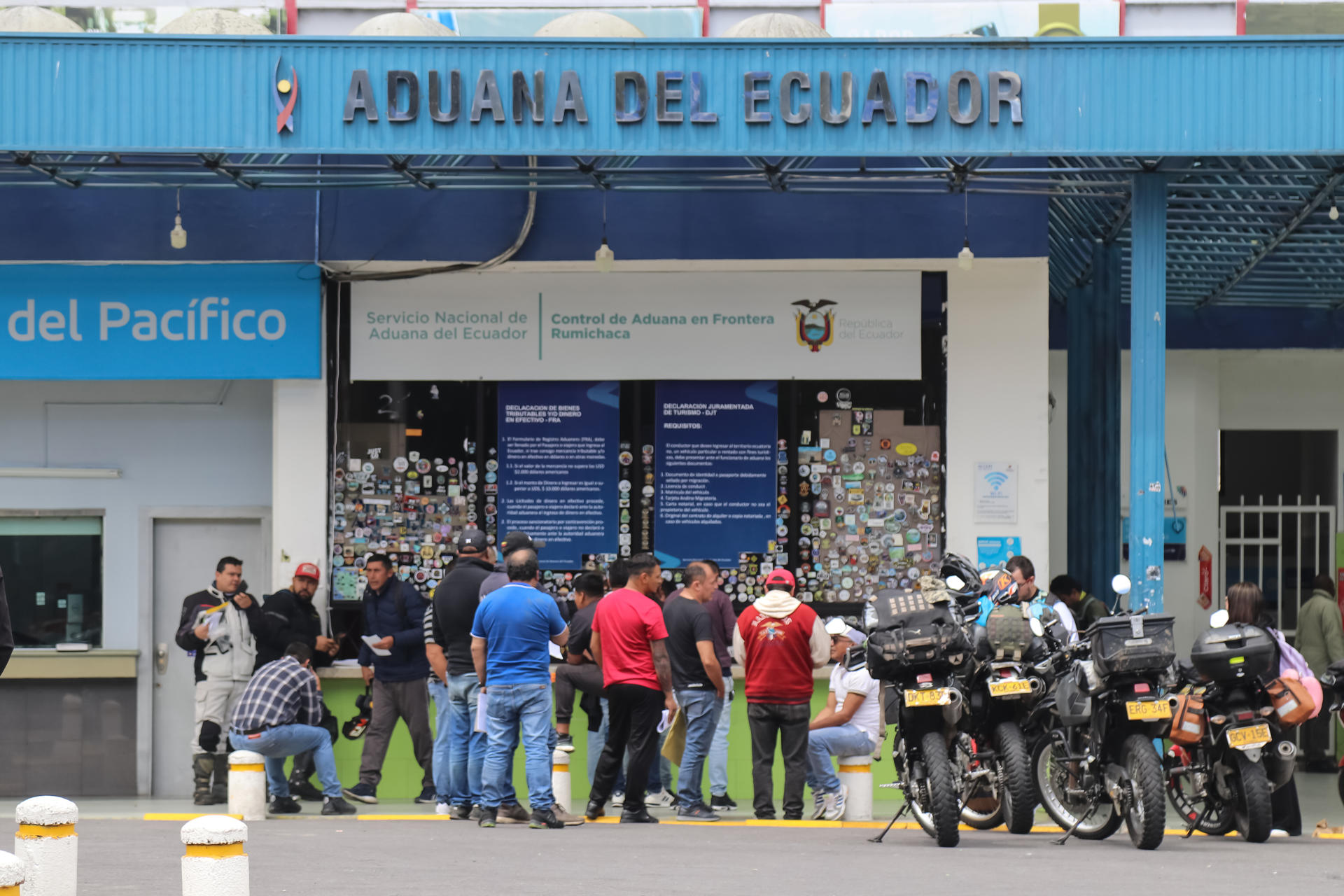 AME7828. TULCÁN (ECUADOR), 23/01/2026.- Personas hacen fila en el Centro Nacional de Atención en Frontera ( Cenaf) en la frontera de Ecuador con Colombia este viernes, en Tulcán (Ecuador). Comerciantes de la ciudad de Tulcán, en la frontera de Ecuador con Colombia, alertaron que la guerra comercial con aranceles de hasta el 30 % anunciados recíprocamente de un país hacia el otro beneficiarán al contrabando, disminuirán el flujo comercial, entorpecerán los trámites aduaneros en la frontera y encarecerán muchos productos en el interior de cada país. EFE/ Xavier Montalvo