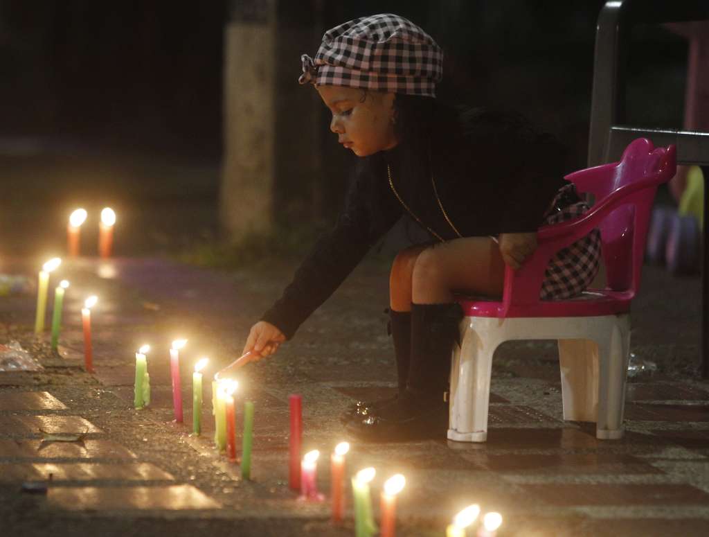 MED108 -MEDELLÍN(COLOMBIA), 07/12/2023. Una niña enciende una vela durante la tradicional noche de las velitas hoy, en Medellín (Colombia). Esta costumbre colombiana celebra el día de la Inmaculada Concepción y marca el inicio de las conmemoraciones navideñas. EFE/Luis Eduardo Noriega Arboleda