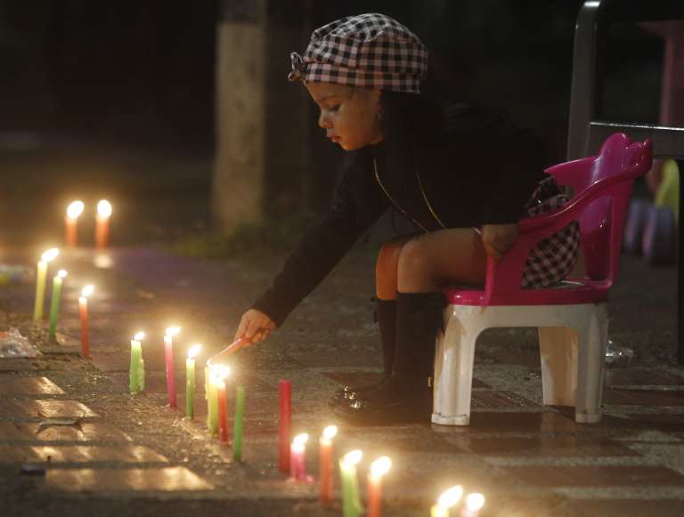 MED108 -MEDELLÍN(COLOMBIA), 07/12/2023. Una niña enciende una vela durante la tradicional noche de las velitas hoy, en Medellín (Colombia). Esta costumbre colombiana celebra el día de la Inmaculada Concepción y marca el inicio de las conmemoraciones navideñas. EFE/Luis Eduardo Noriega Arboleda