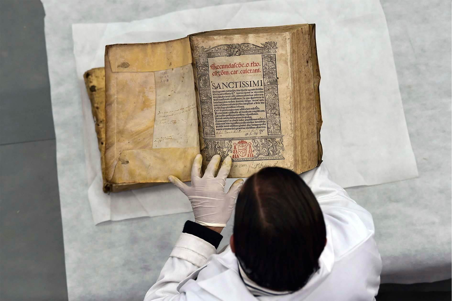 Restauradores Intentan alargar la vida a miles de libros, algunos con más de 500 años, que resultaron afectados indirectamente por el terremoto que sacudió a Ecuador en 2016. / Rodrigo BuendIa - AFP